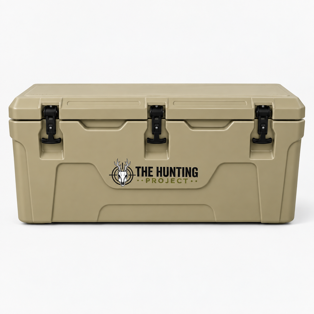 A tan heavy-duty cooler with black latches and a black and white 'THE HUNTING PROJECT' logo on the front, set against a plain white background.