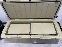 A large beige insulated cooler box with its lid open, showing two smaller matching cooler boxes nested inside on a gray tiled floor.